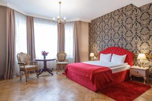 布拉索夫蒙特沃德之家旅馆的一间卧室配有红色的床和桌椅