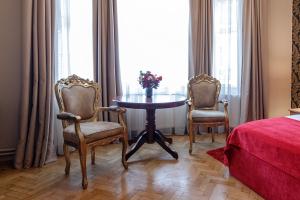 布拉索夫蒙特沃德之家旅馆的配有桌子和两把椅子及一张床的房间