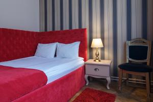 布拉索夫蒙特沃德之家旅馆的一间卧室配有红色的床和椅子