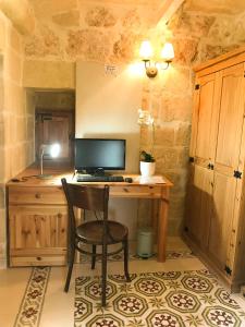 沙拉L'Gharix Temple Retreat的一张桌子,一张桌子,一台电脑和一把椅子放在一个房间里