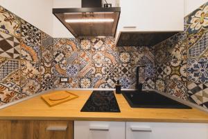 切法卢卡拉格兰德住宿公寓式酒店的厨房的墙壁上设有瓷砖和水槽。