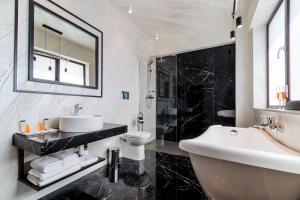 拉姆尼库沃尔恰Hotel Bulevard的黑白浴室设有水槽和浴缸。