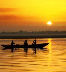 瓦拉纳西Amritara Suryauday Haveli的一群人,在日落时分在水面上