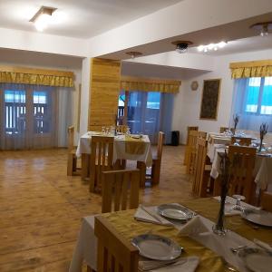 SviniţaCONACUL SARBESC的用餐室设有桌椅和窗户。