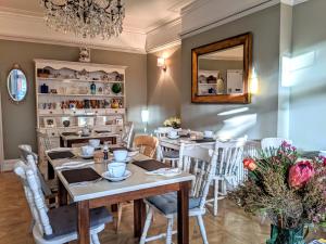 伯恩茅斯Alexander Lodge Guest House的一间带桌椅和镜子的用餐室