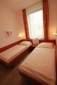 埃斯彭瑙Gästehaus Waldeslust的酒店客房设有两张床和窗户。