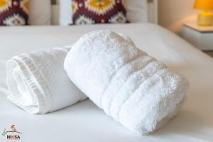 韦林花园城Niksa Serviced Accommodation Welwyn Garden City- One Bedroom的睡床上的白色毛巾