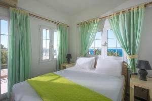 费马Elena's Beach Garden by Estia的一间卧室配有一张带绿色窗帘和窗户的床。