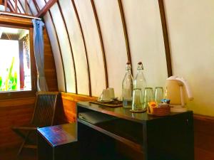 吉利特拉旺安红棉树小屋旅馆的桌子上装有瓶子,上面装有椅子