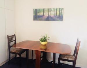 East AnsteyEdge of Exmoor Garden Flat, dog friendly, sleeps 2 - 4的一张木桌,上面有两把椅子和一株植物