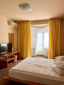 克卢日-纳波卡维多利亚酒店的一间卧室配有一张大床和电视
