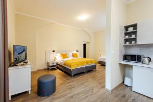 特伦钦温泉镇Apartmánový dom GRAND - Contactless Check In的一间卧室配有一张床,并在一间客房内配有电视。