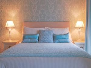 佩恩顿amber house hotel的一间卧室配有一张带蓝色枕头的床和两盏灯。