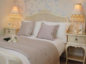 佩恩顿amber house hotel的一张带两张桌子和两盏灯的白色床