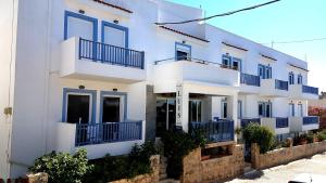 马斯蒂查里Luis Apartments的白色的房子,在街上设有蓝色的阳台