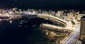 卡马里尼亚斯Pension Catro Ventos的夜间在水中乘船欣赏海港景色