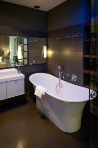 开普敦Purple House Accommodations的带浴缸和盥洗盆的大浴室