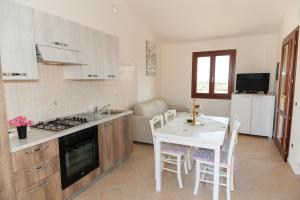 布多尼Corte di Gallura的厨房配有桌子和炉灶。 顶部烤箱