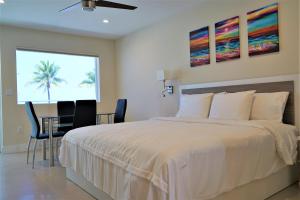 好莱坞Diane Oceanfront Suites的一间卧室配有一张床、一张桌子和一棵棕榈树