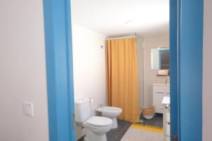 卡帕里卡海岸Maria Tereza Sea Villa的浴室设有卫生间和黄色的淋浴帘
