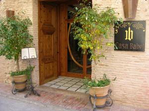 Villalonga卡萨巴贝尔酒店的前方有两株盆栽植物的餐厅的门