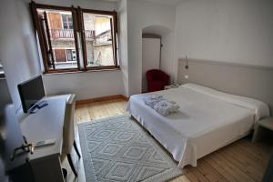 特伦托艾尔伯格阿卡戴米亚酒店的卧室配有白色的床和窗户。