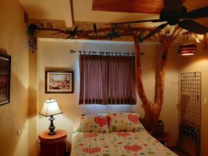 纽沃阿雷纳尔Marita's Bed and Breakfast的卧室配有树木主题的床和吊扇