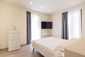 特拉帕尼Aria di Mare Apartments的卧室配有一张床,墙上配有电视。
