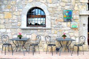 SerleAgriturismo dell'Altopiano的石墙前的四张桌子和椅子