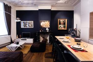 列日GITADIN - Deluxe Suite Rousseau - Historical center的客厅配有桌子和沙发