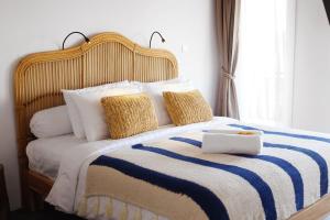 坎古Amar Boutique Hotel的一张带蓝色和白色毯子及枕头的床