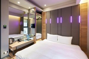 中坜奇异果共享旅店-中坜车站店的卧室配有一张白色大床和镜子