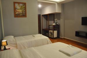 沙湾拿吉朝圣者厨房宾馆的酒店客房设有两张床和电视。