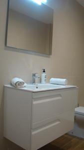 桑坦德Apartamentos LA PEREDA SANTANDER的浴室设有白色水槽和镜子