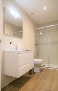 桑坦德Apartamentos LA PEREDA SANTANDER的白色的浴室设有水槽和卫生间。