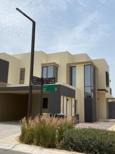 迪拜5 bedroom Villa - Dubai Hills的前面有路标的房子