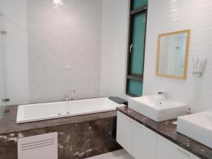 台中市一中太陽綠墅的浴室设有2个水槽、浴缸和镜子