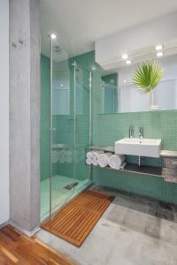 布拉格Holečkova Apartments的一间带玻璃淋浴和水槽的浴室