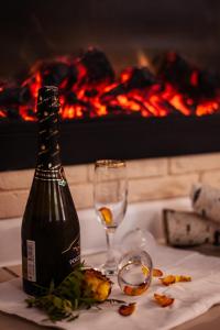 巴尔瑙尔"Отель 24 часа"的壁炉桌子上放有一瓶葡萄酒和玻璃杯