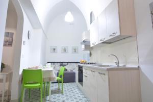 卡斯特里尼亚诺德尔卡波Lu Trisciulu的一间厨房,内设一张桌子和绿色椅子