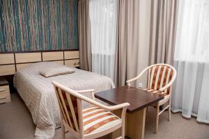 斯捷尔利塔马克Grand Hotel Vostok的卧室配有一张床和一张桌子及椅子