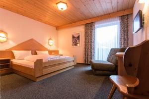 考恩台尔海福乐酒店的卧室配有床、椅子和窗户。