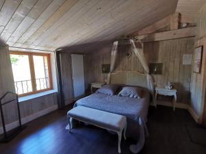 ViscomtatLe Moulin de la Fortie, maison d'hôtes的一间卧室配有一张床、一张桌子和一个窗户。