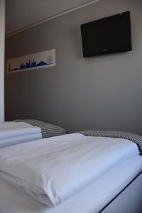 维也纳新村HB1 Budget Hotel - contactless check in的一间卧室设有两张床,墙上设有一台平面电视。