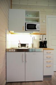 阿灵索斯Alingsås Golfklubb的厨房配有白色橱柜和微波炉