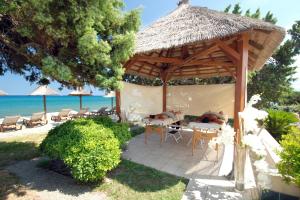 林古泽塔Camping Naturiste Riva Bella 4*的海滩上带桌椅的凉亭