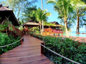 沙拉海滩沙拉德小屋酒店的通往棕榈树度假村的木制走道