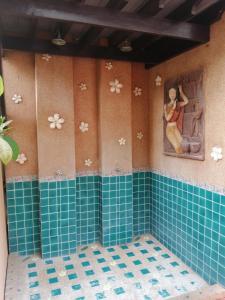 华欣华欣瓦纳雷酒店的浴室铺有蓝色瓷砖,墙上挂有绘画作品