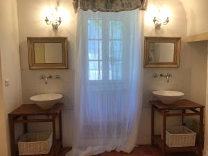 梅内尔伯Le mas jasmins的一间带两个盥洗盆的浴室和一个大窗户
