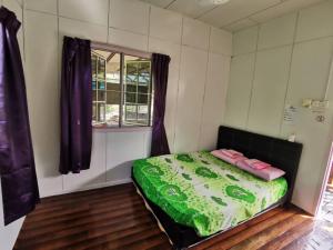 古打毛律Tambatuon Homestead的一间带床的卧室,位于带窗户的房间内